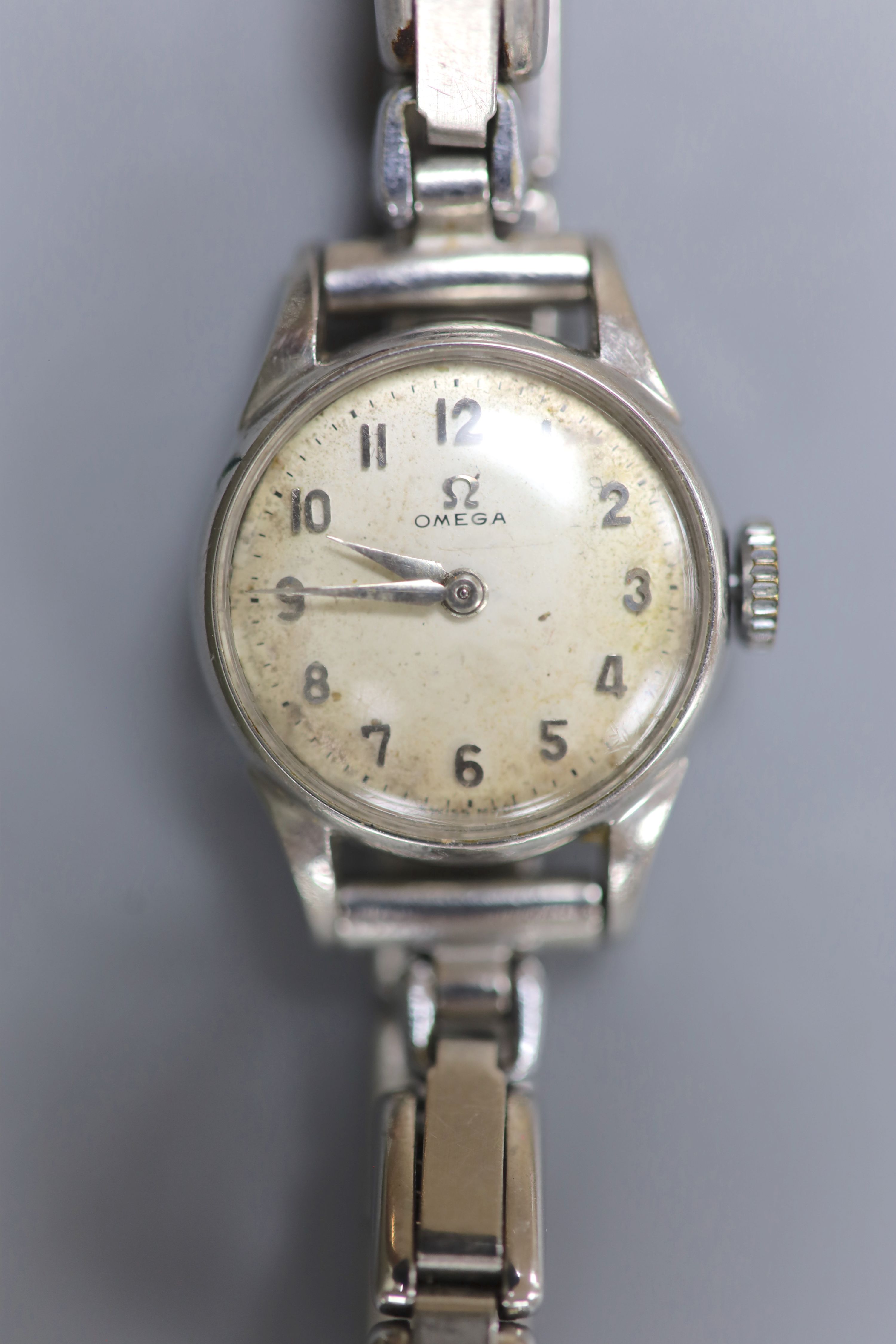 A lady's stainless steel Omega manual wind wrist watch, on associated flexible bracelet.